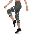 Load image into Gallery viewer, Elevate your wardrobe with these Elevated Essence Capris, the perfect addition to your athleisure collection. These capris feature a sleek and stylish design with white horizontal lines on a dark grey base, creating a striking yet versatile look that can be dressed up or down. The four-way stretch fabric ensures a comfortable and flexible fit, while the high-rise waistband offers support and coverage.