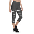 Load image into Gallery viewer, Elevate your wardrobe with these Elevated Essence Capris, the perfect addition to your athleisure collection. These capris feature a sleek and stylish design with white horizontal lines on a dark grey base, creating a striking yet versatile look that can be dressed up or down. The four-way stretch fabric ensures a comfortable and flexible fit, while the high-rise waistband offers support and coverage.