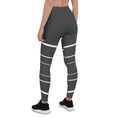 Load image into Gallery viewer, Elevate your daily style with these versatile and comfortable leggings. The unique white lines against the dark grey background make a bold statement that's perfect for any occasion. From yoga classes to brunch with friends or a night out on the town, these leggings will keep you looking and feeling your best.