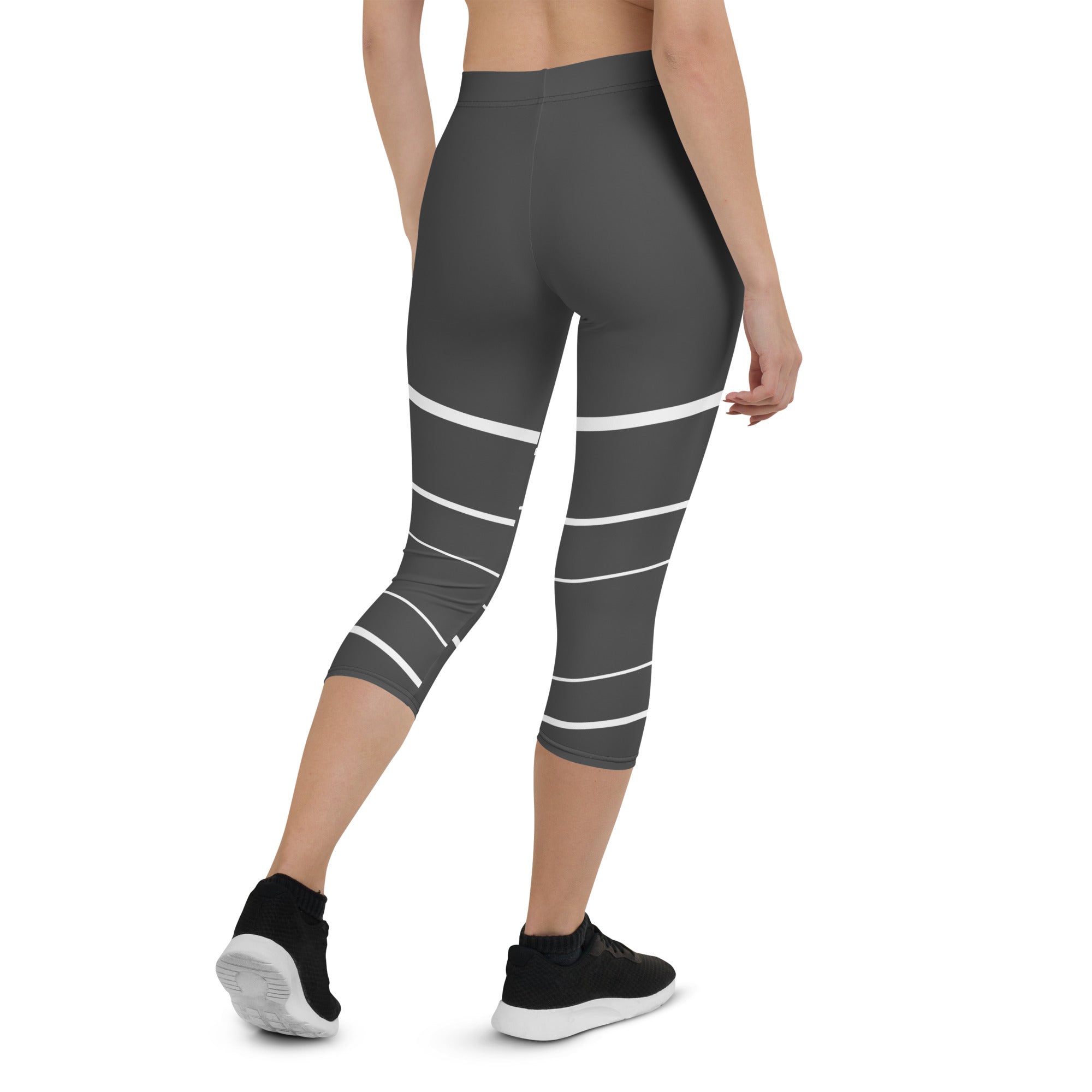 Elevate your wardrobe with these Elevated Essence Capris, the perfect addition to your athleisure collection. These capris feature a sleek and stylish design with white horizontal lines on a dark grey base, creating a striking yet versatile look that can be dressed up or down. The four-way stretch fabric ensures a comfortable and flexible fit, while the high-rise waistband offers support and coverage.